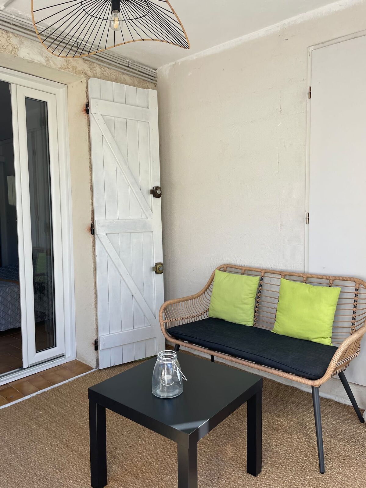 La terrasse couverte de l'appartement, avec sa banquette en rotin